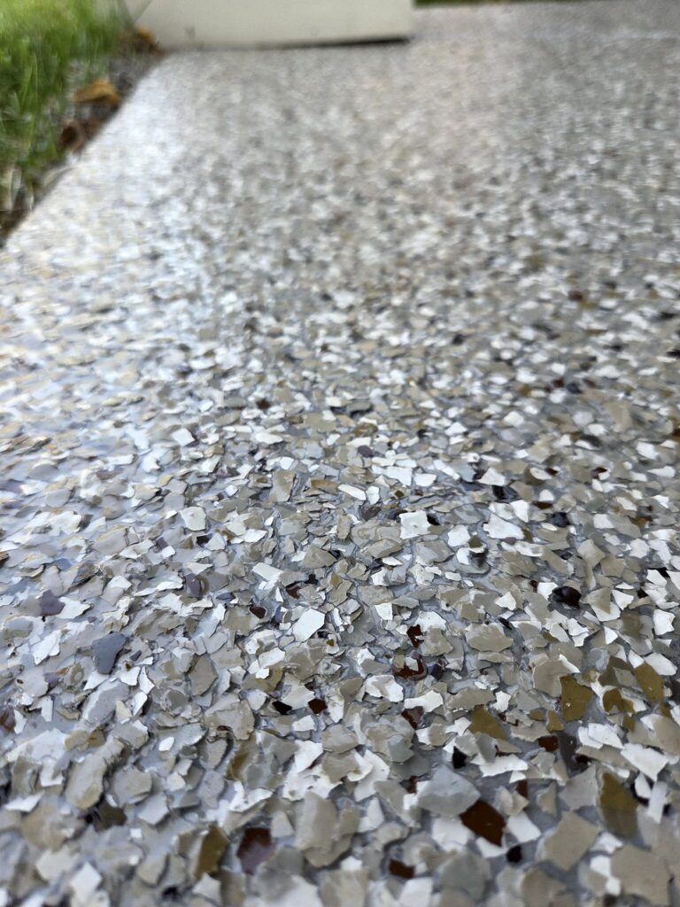 Close-up of a gray flake coating on a covered porch in Oconomowoc