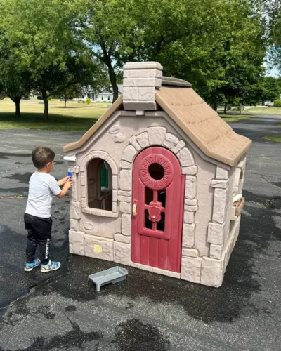 Chad's son painting a playhouse with a roller