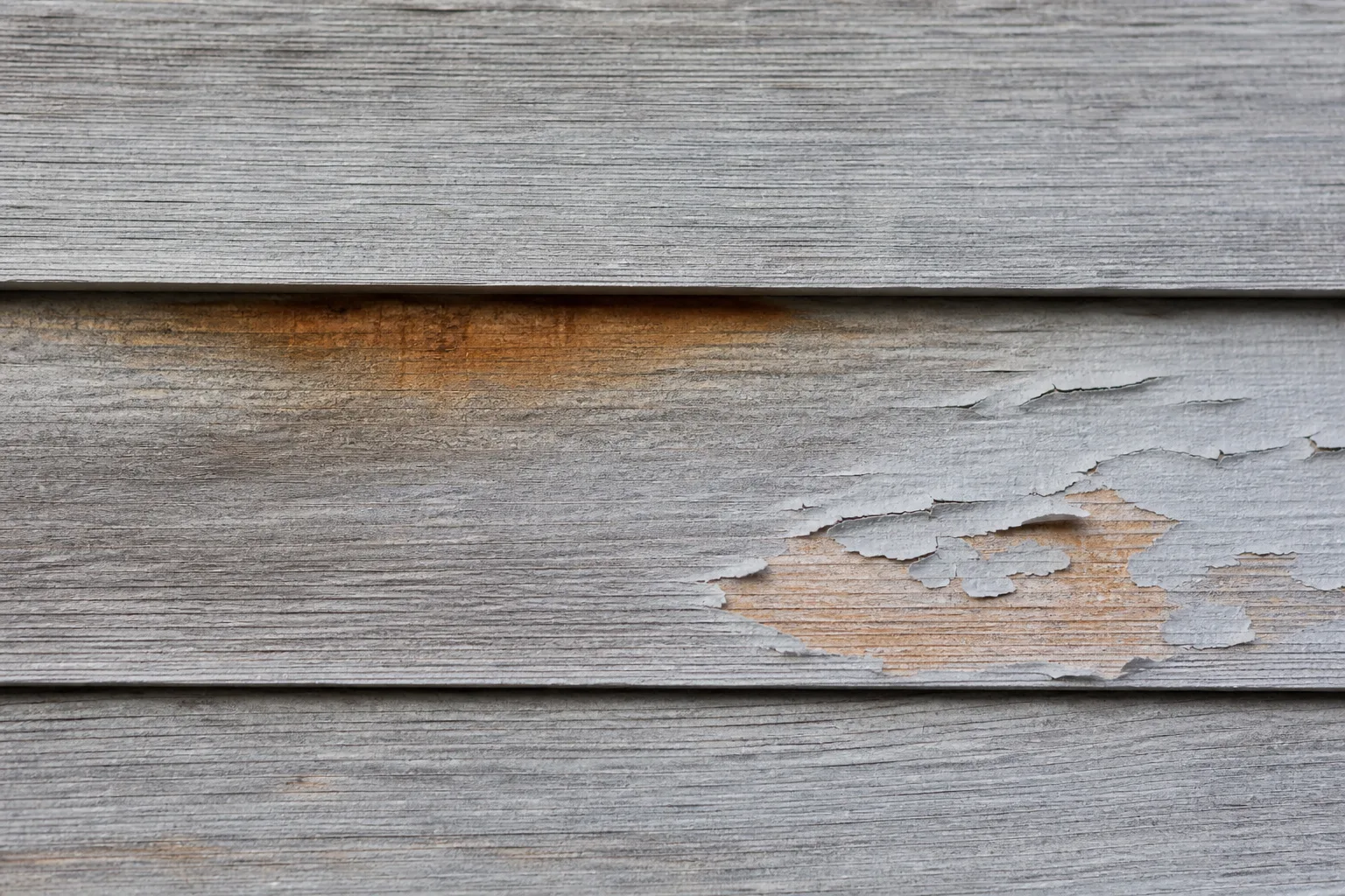 Illustration of weathered cedar siding with discoloration and peeling coating