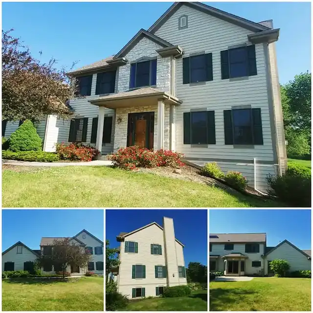 Two-story gray house with stone facade and dark shutters