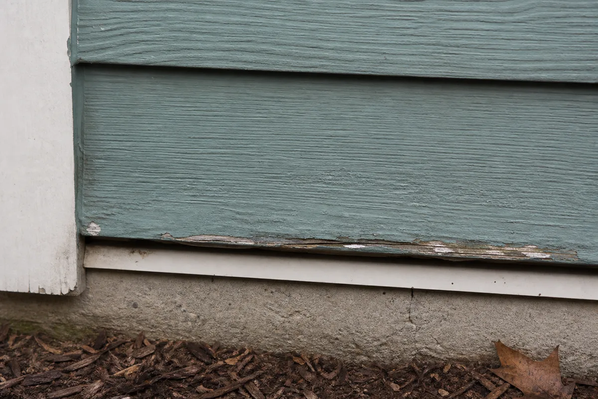 Illustration of bottom-edge coating wear and swelling on engineered wood siding