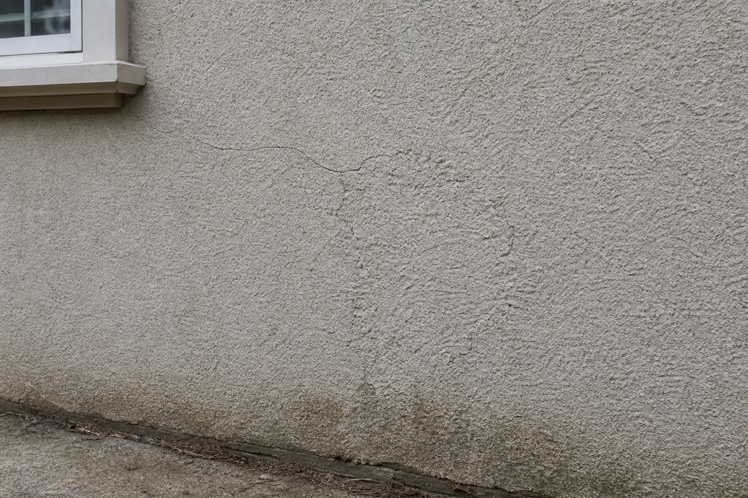 Illustration of a crack, patch, and moisture staining on textured stucco