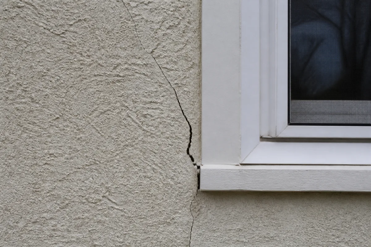 Illustration of an open stucco crack beside an exterior window corner