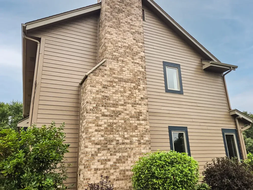 Full exterior repaint with tan siding and dark trim on a home in Eagle, WI
