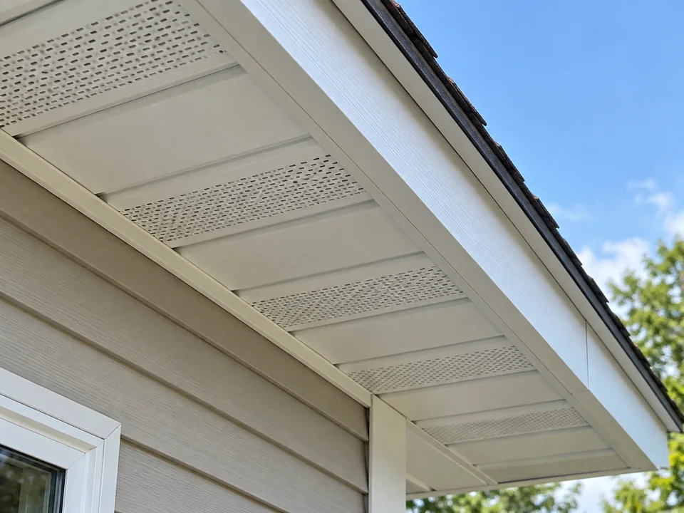 Vented soffit panels and painted fascia beneath a residential roof eave
