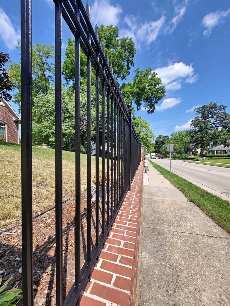 Black steel fence posts on a brick wall in Oconomowoc