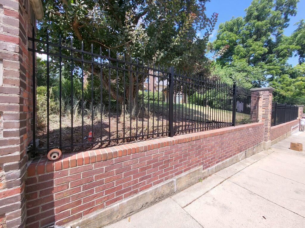 Black metal fence brick wall in Oconomowoc