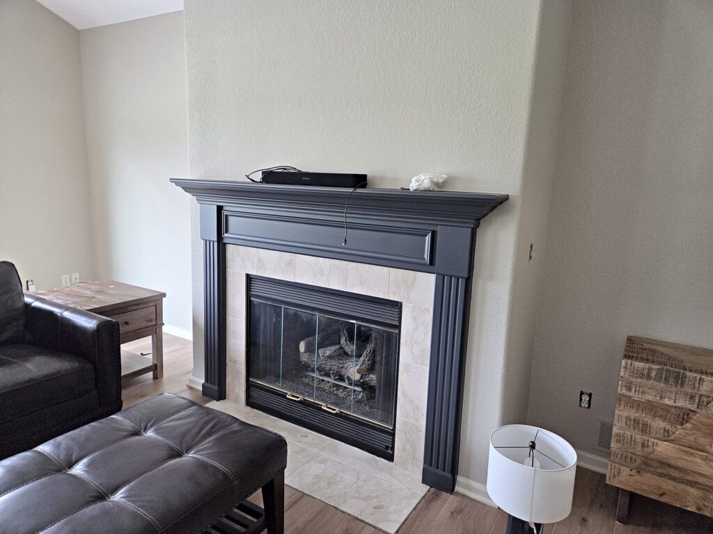 Dark fireplace mantel light walls in North Prairie