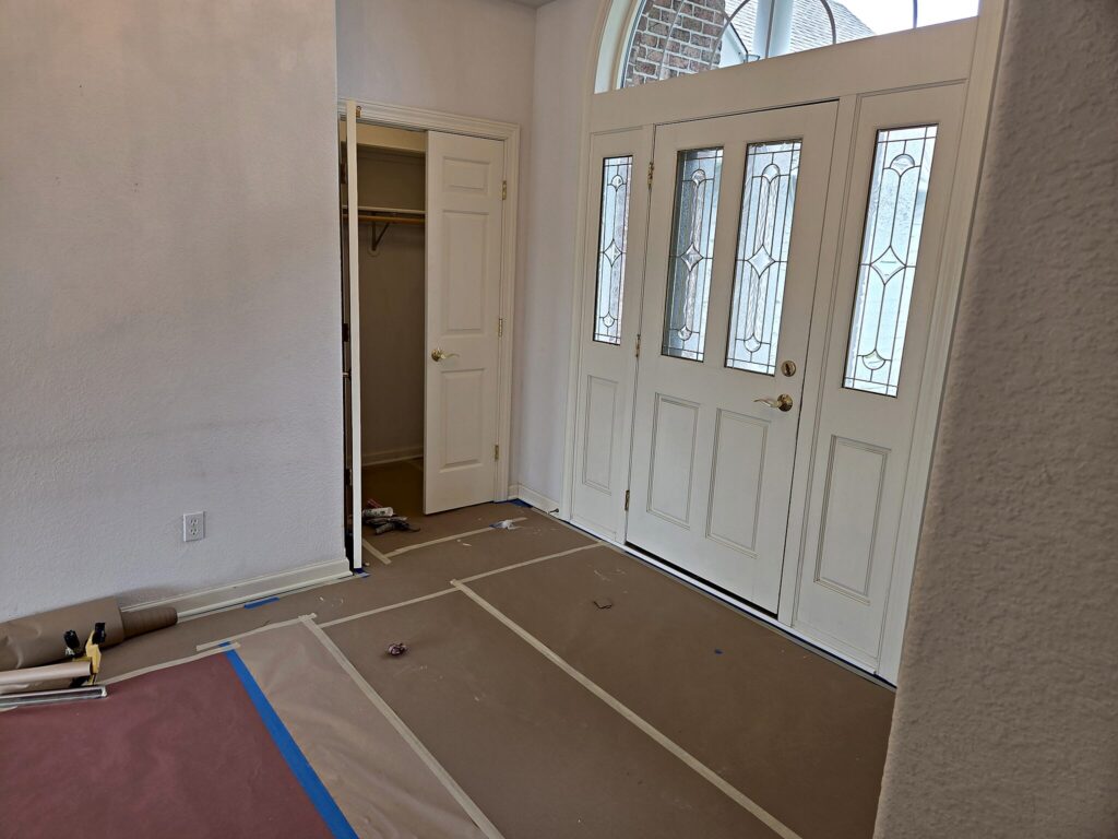 Entry hall with floors protected before an interior repaint in North Prairie