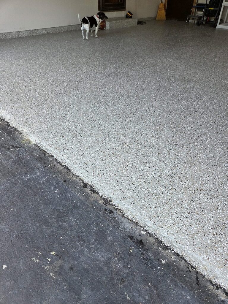 Gray flake coating on a garage floor meeting the asphalt driveway in Mukwonago
