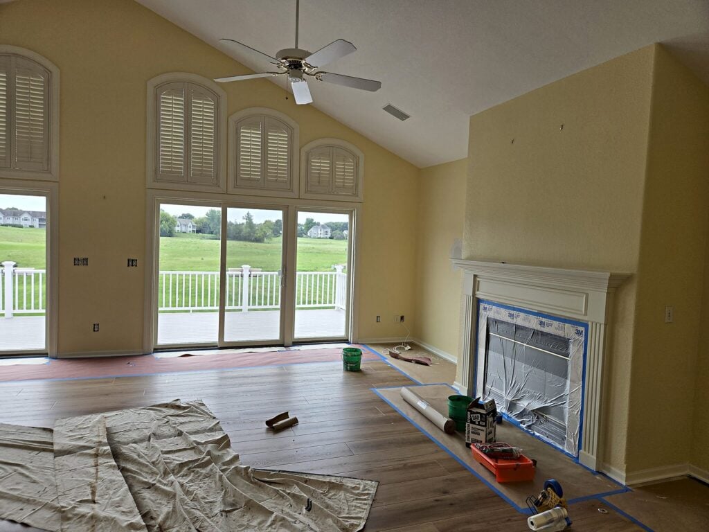 North Prairie living room with floors covered and fireplace masked before repainting