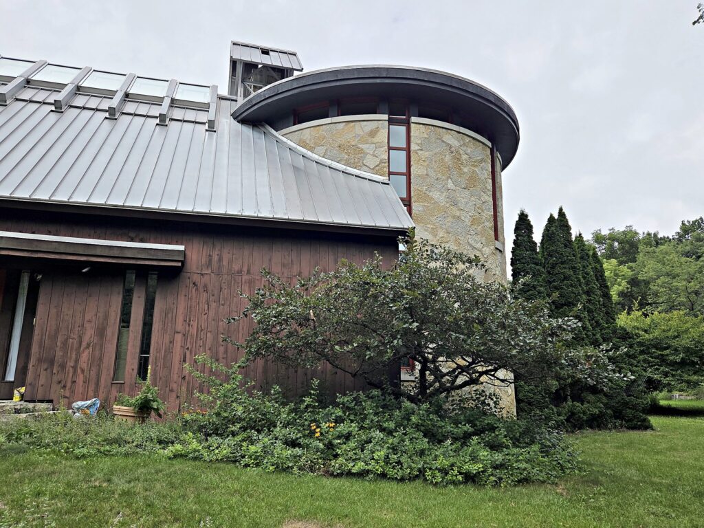 Contemporary Mukwonago home with stone towers and dark-stained cedar siding