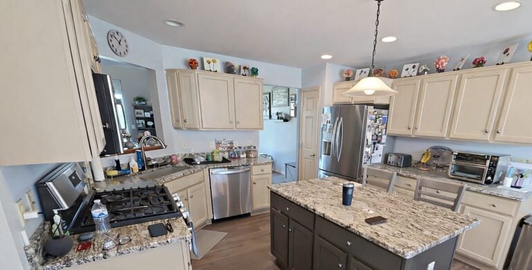 Painted cream kitchen cabinets and a dark gray island in a Waukesha home